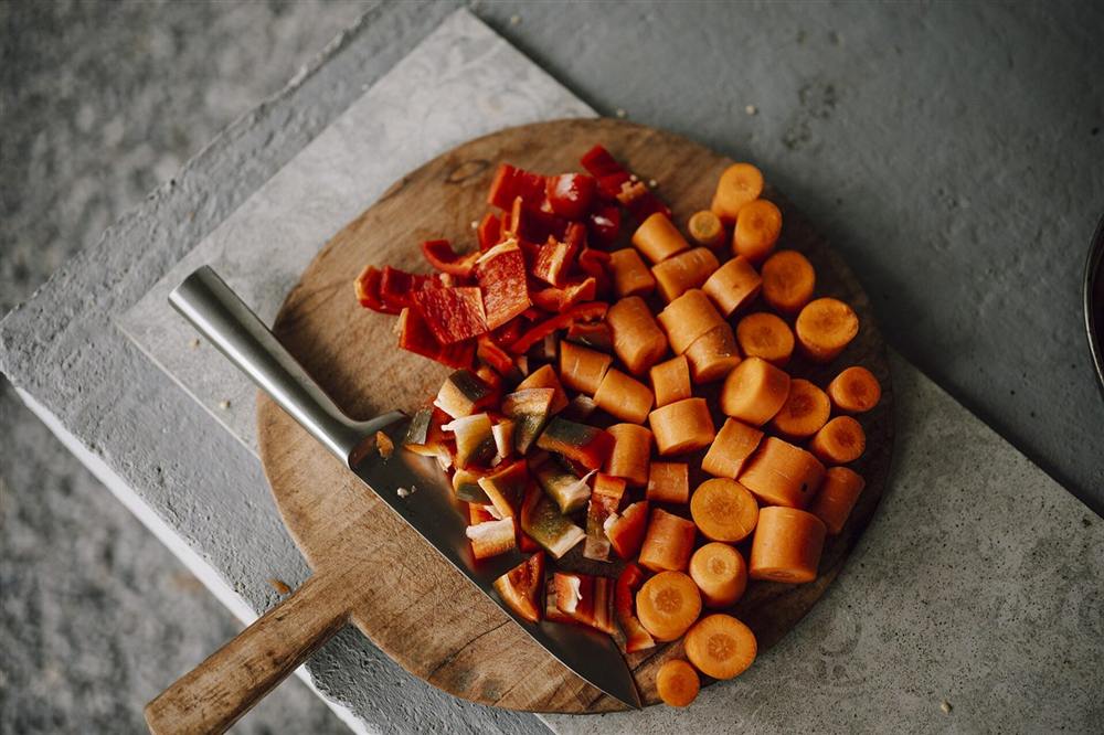 Legumes e verduras já cortados sobre tábua de madeira